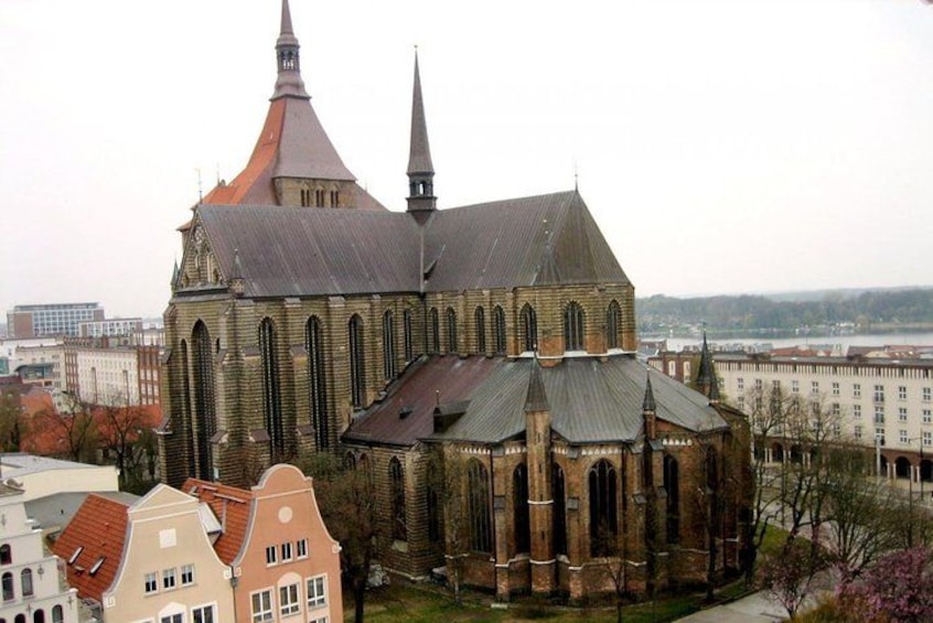 Una iglesia histórica con un campanario destacado y un edificio adyacente más pequeño con una cúpula. 4