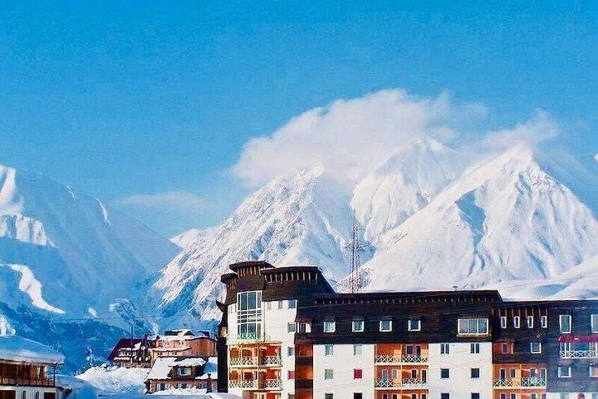 Un balneario de montaña con picos nevados y edificios de colores. 4