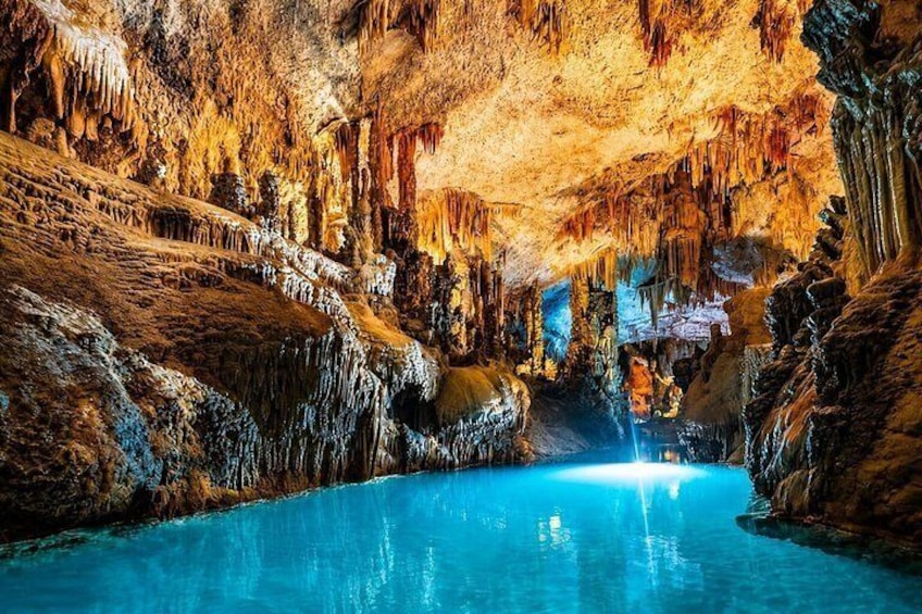 A cave with stalactites and a pool of water. 1