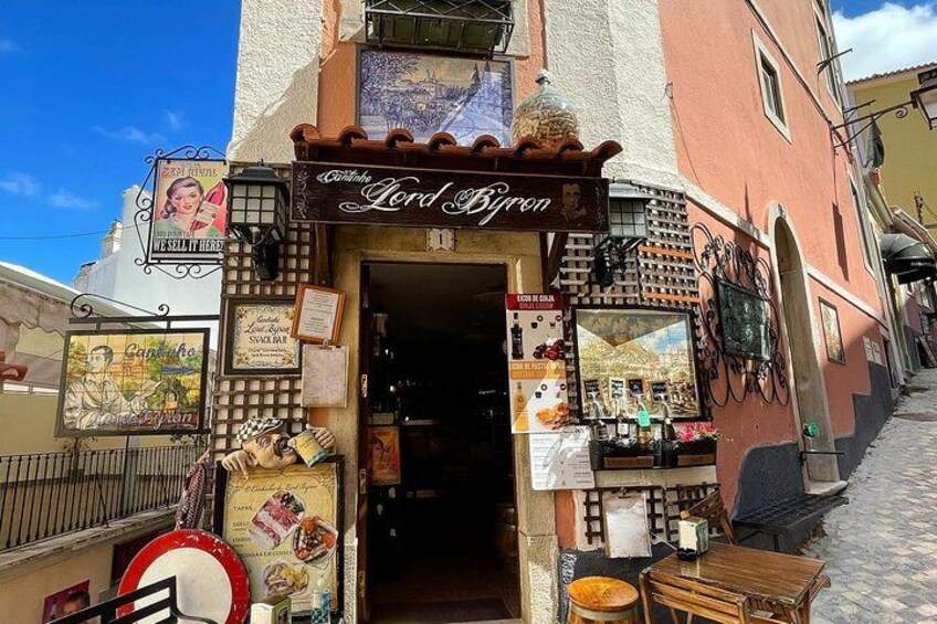 A storefront with a sign reading 'Lord Byron' and various posters and advertisements. 4