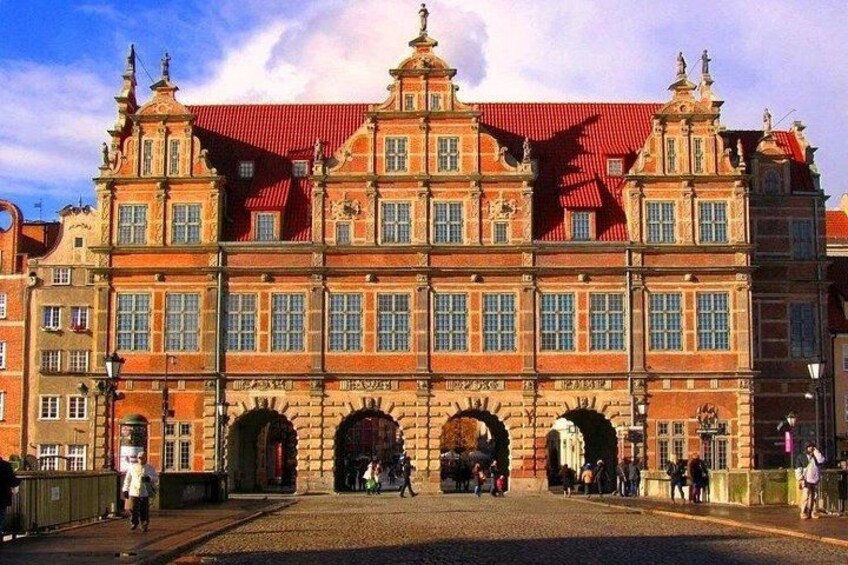 A historic building with a red roof and multiple arches. 3