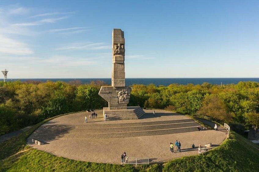 A monument with a tall, rectangular base and a stepped structure in the center, surrounded by a circular plaza with steps leading up to it. 2