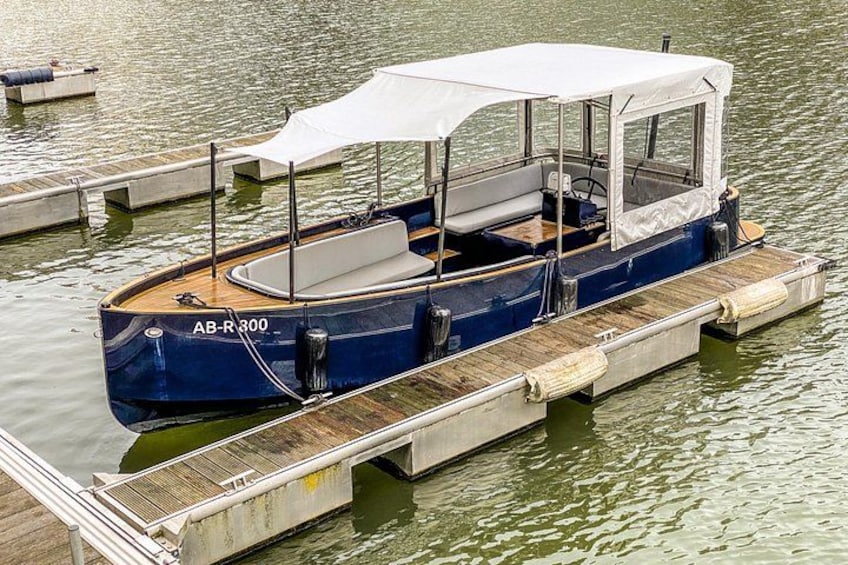 A blue boat with a white canopy docked at a wooden pier. 3