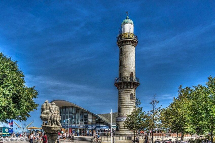 A historic tower with a dome, surrounded by trees and a modern building with a curved facade. 1