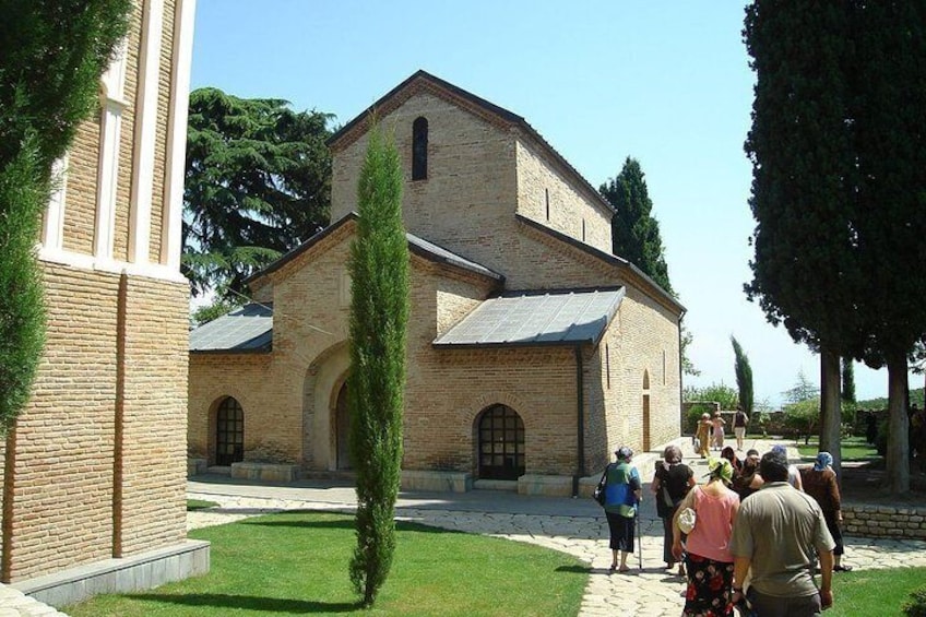 A historic church with a brick facade and arched windows, surrounded by a well-maintained lawn and tall trees. 4