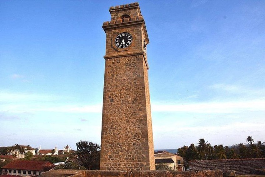 A tall stone clock tower with a clear sky in the background. 1