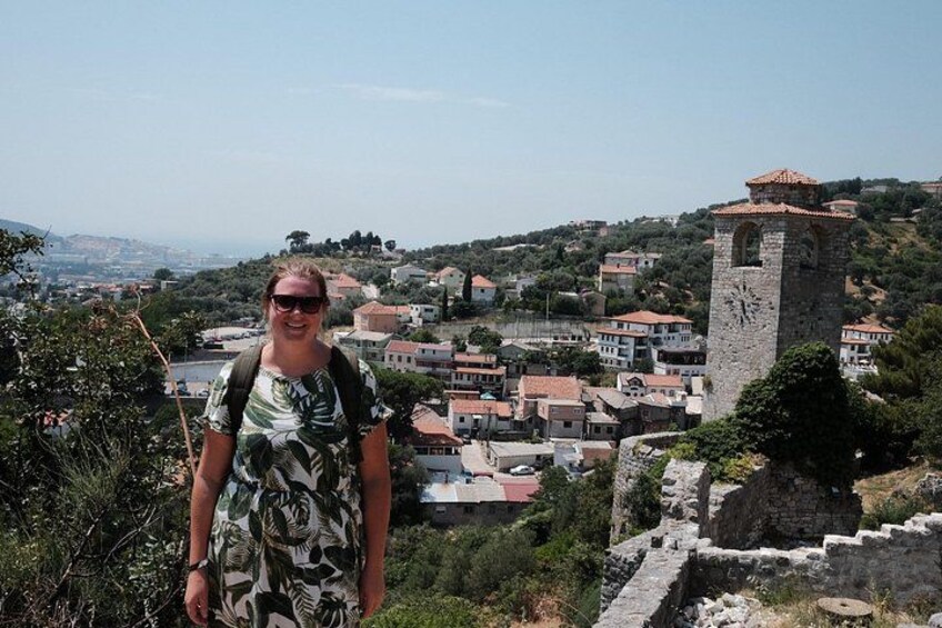 A person standing on a hill overlooking a town with a prominent tower. 3