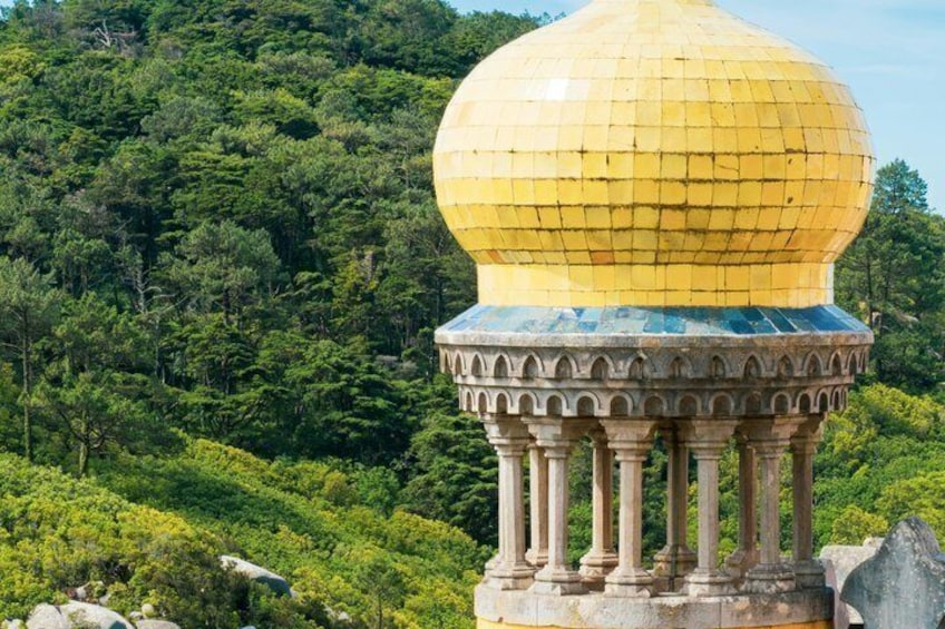 Una struttura a cupola gialla su una base blu, immersa in una rigogliosa foresta verde. 2