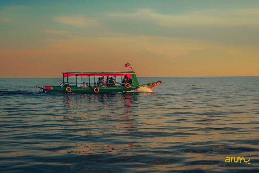 Ein Boot mit Passagieren auf ruhiger See während des Sonnenuntergangs. 4