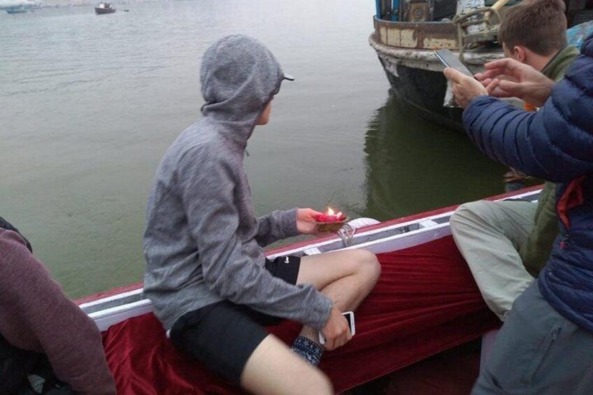 A person sitting on a boat, holding a smartphone. 4
