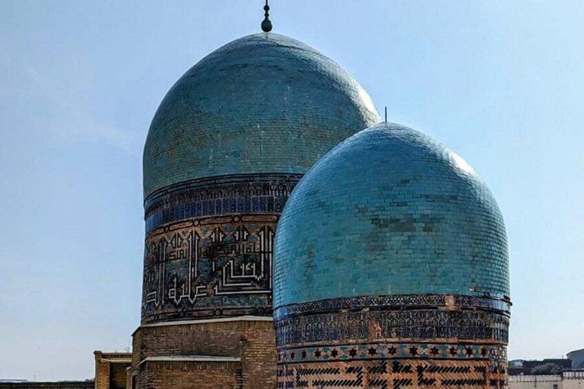 A mosque with two large domes and intricate tile work. 4