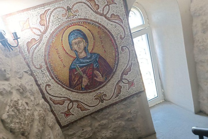 A mosaic with a central figure, surrounded by decorative patterns. 2