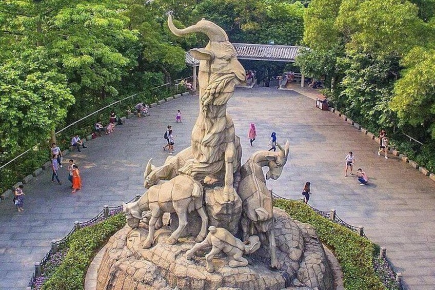 Una gran escultura de piedra de una criatura mítica rodeada por un paseo circular con gente caminando. 3