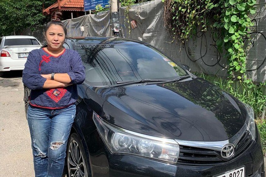 A black car parked on a street with a person standing beside it. 5