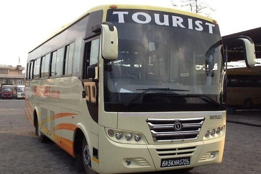 A tourist bus with the word 'TOURIST' on the front, a license plate, and a side design. 4