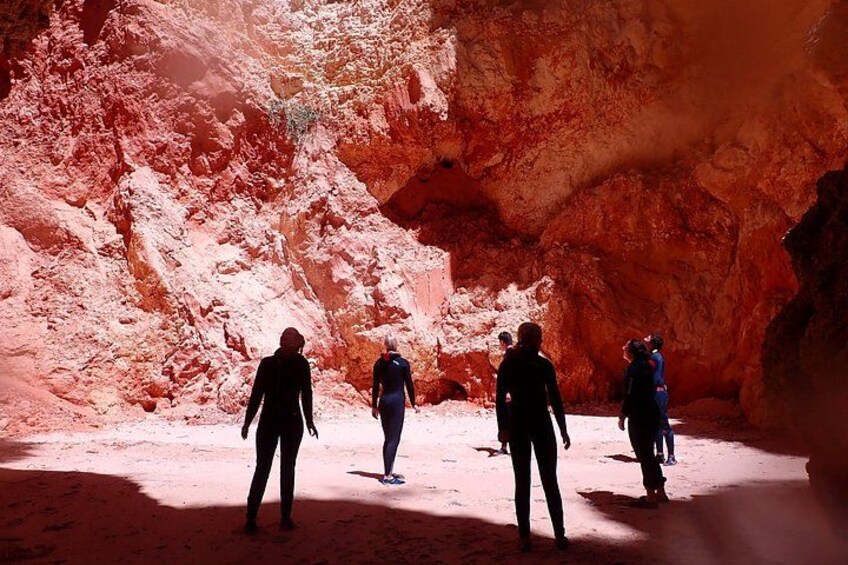 A group of people hiking in a red rock canyon. 3