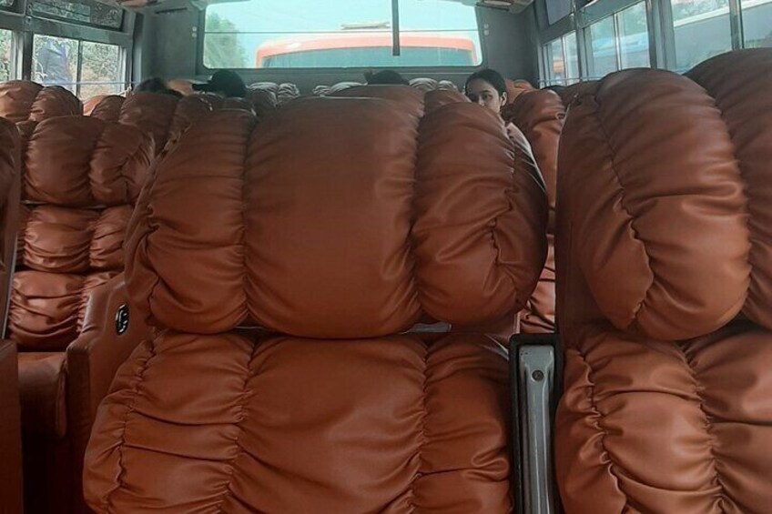 The interior of a bus with brown leather seats. 4