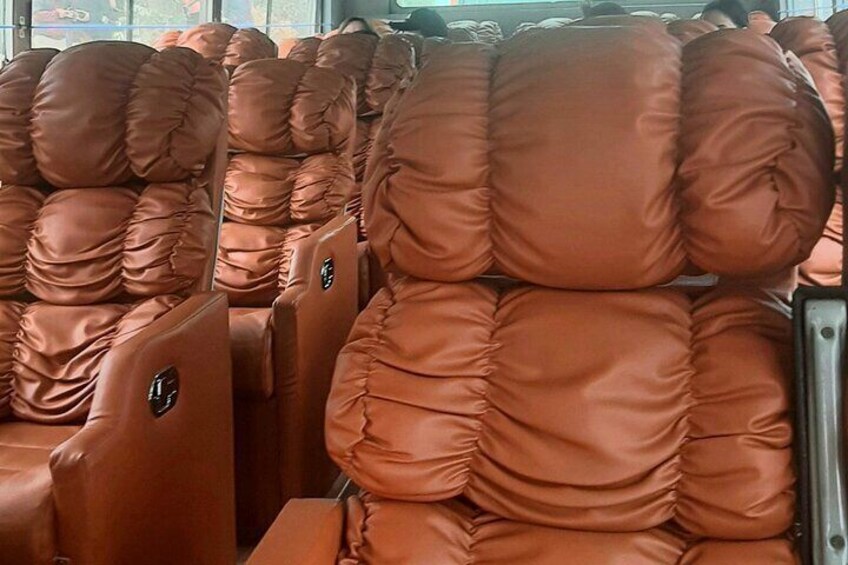 Rows of brown leather seats with a logo on the backrest. 2