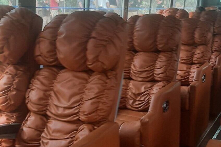Rows of brown leather seats with a high backrest. 3