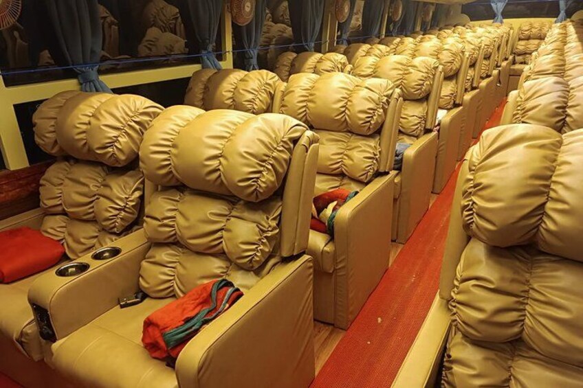 Rows of plush, beige upholstered seats with red cushions and a red carpet. 1