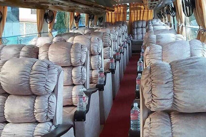 A train carriage with rows of cushioned seats and a red carpet. 4