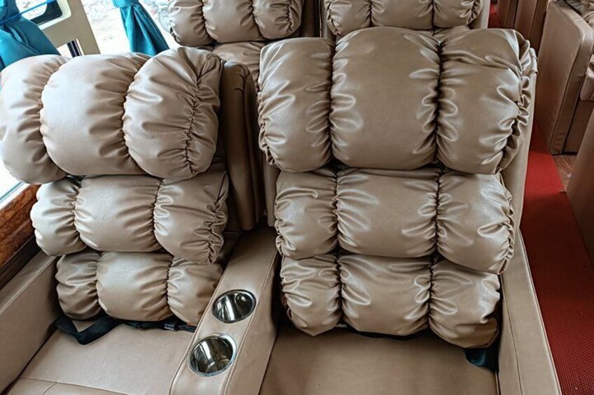 A beige upholstered sofa with multiple cushions and two metal bowls on the floor. 5