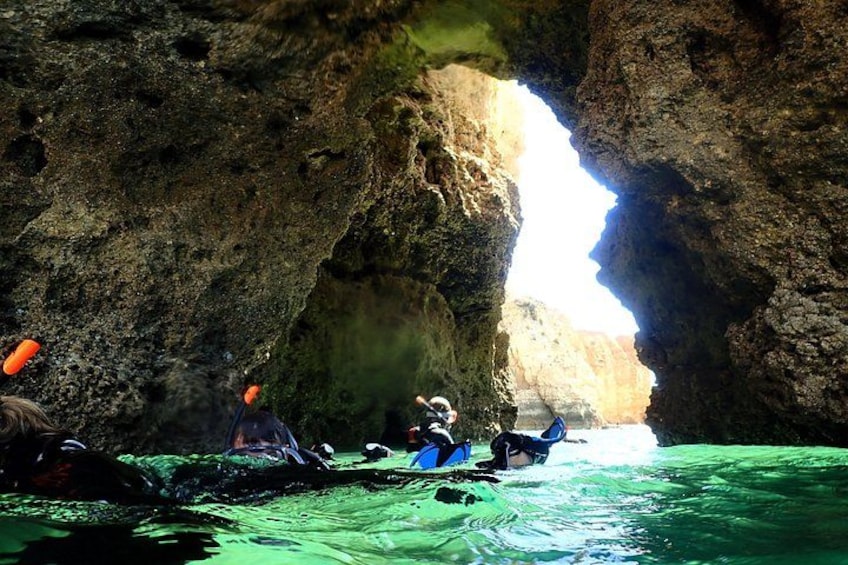 People kayaking in a rocky cave with water. 2
