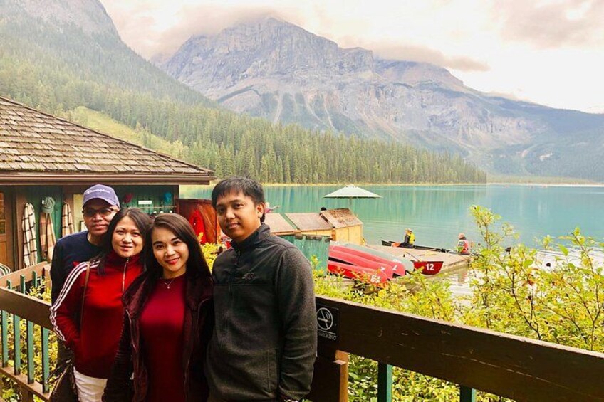 Un groupe de personnes se trouve sur un balcon donnant sur un lac, avec des montagnes en arrière-plan. 4