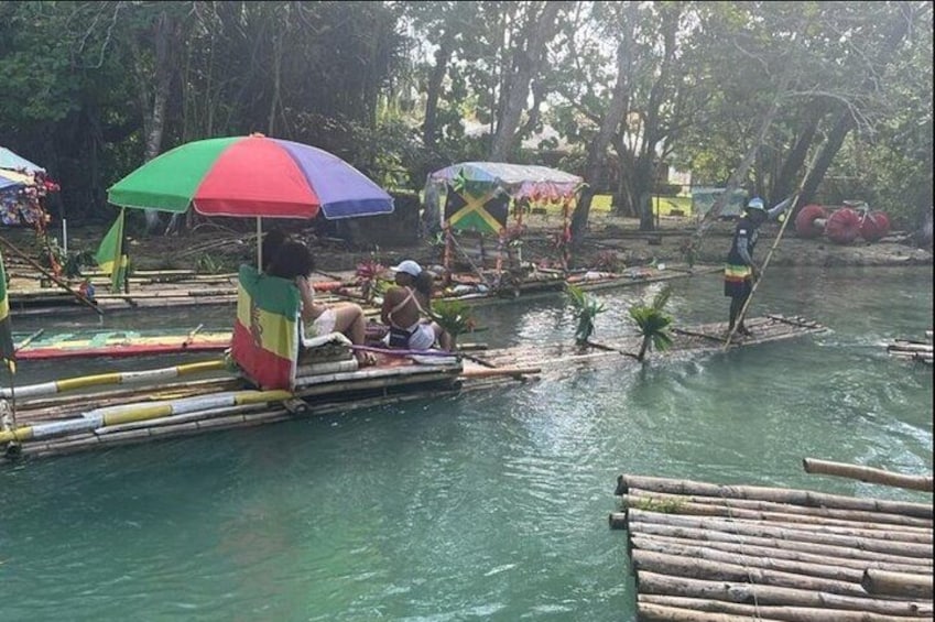 Menschen auf schwimmenden Plattformen mit bunten Regenschirmen in einem Fluss. 3