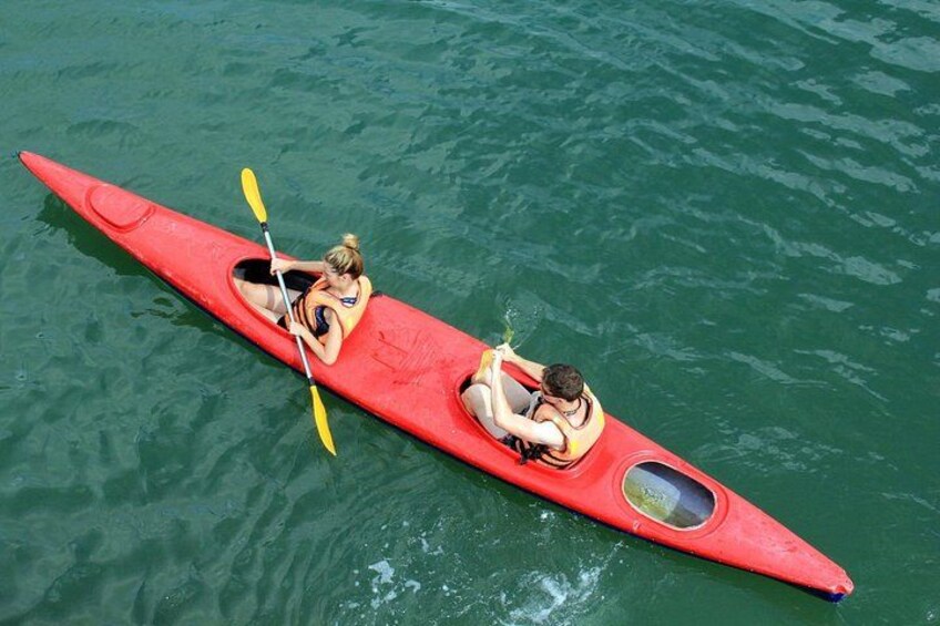 Two people kayaking on a red kayak in calm water. 4