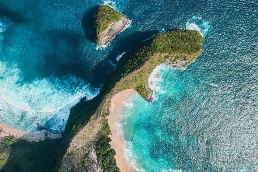Vista aérea de una zona costera con dos pequeñas islas, aguas turquesas cristalinas y una playa de arena. 1
