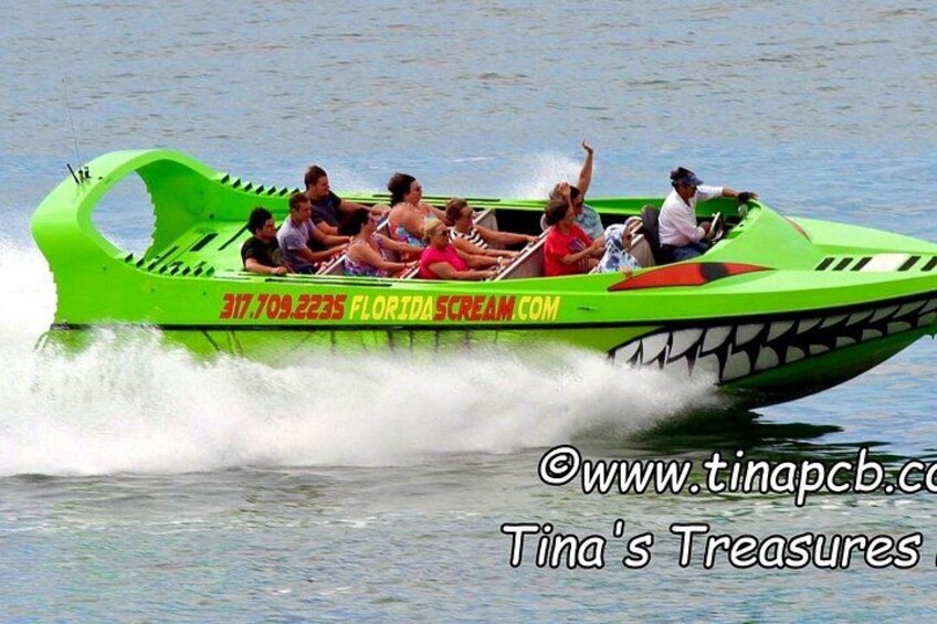 A green speedboat with people on board, moving on water. 4