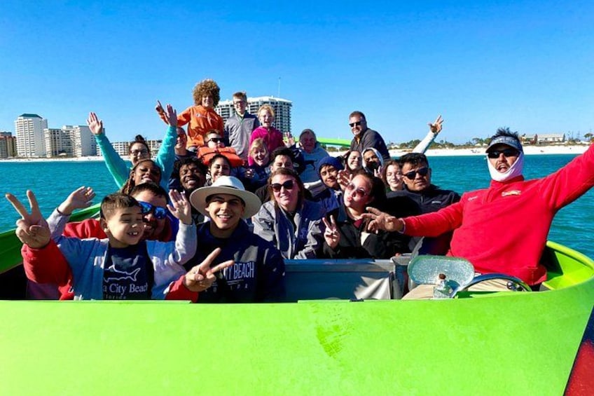 Un grupo de personas en un barco, con el horizonte de una ciudad al fondo. 2