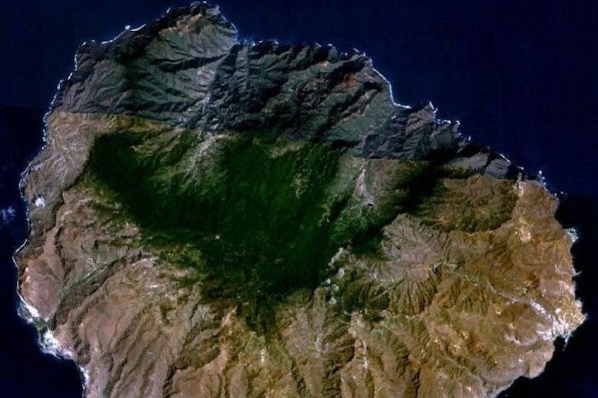 Vista satelital de una isla montañosa con terreno escarpado y un denso bosque verde en el centro. 2