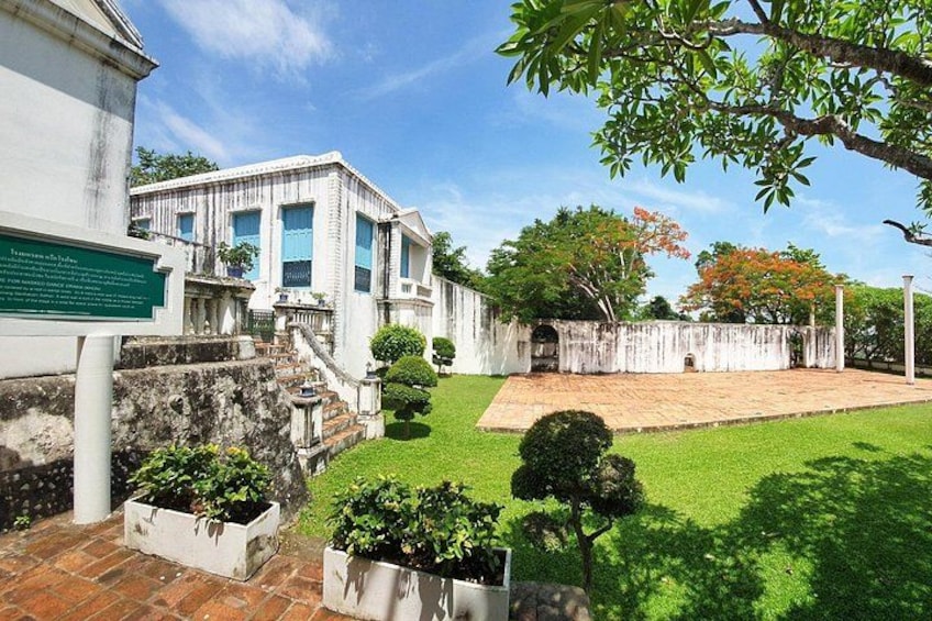 A colonial-style house with a well-maintained lawn, a stone wall, and a wooden fence. 4
