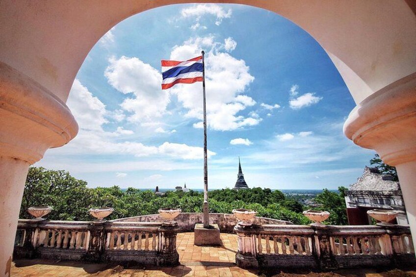 A flagpole with a flag, a temple, and a clear sky. 2