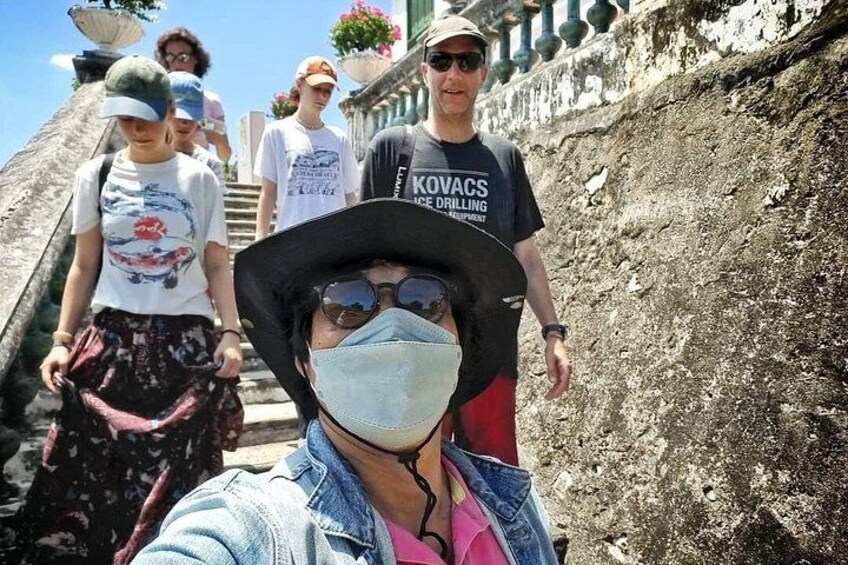 A group of people walking on a stone pathway with a wall on one side. 3
