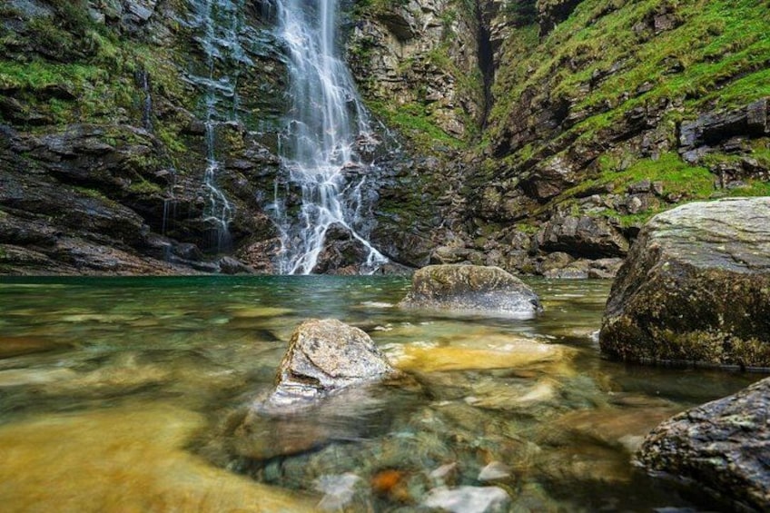 A waterfall, clear water, and rocky terrain. 2