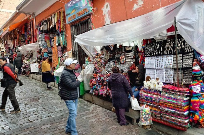 A street market with various stalls selling textiles and accessories. 3