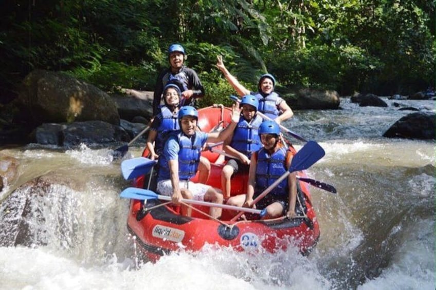 A group of people in a red raft navigating a river with rapids. 2