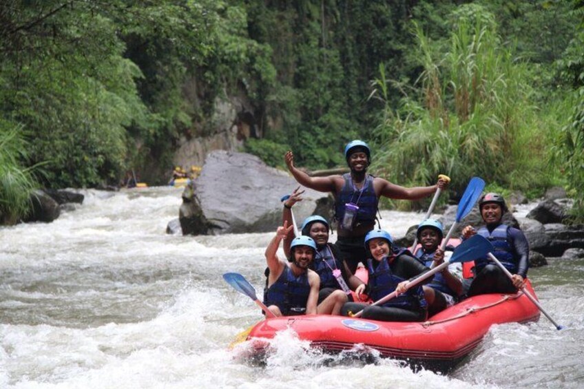 A group of people rafting on a river surrounded by greenery. 3