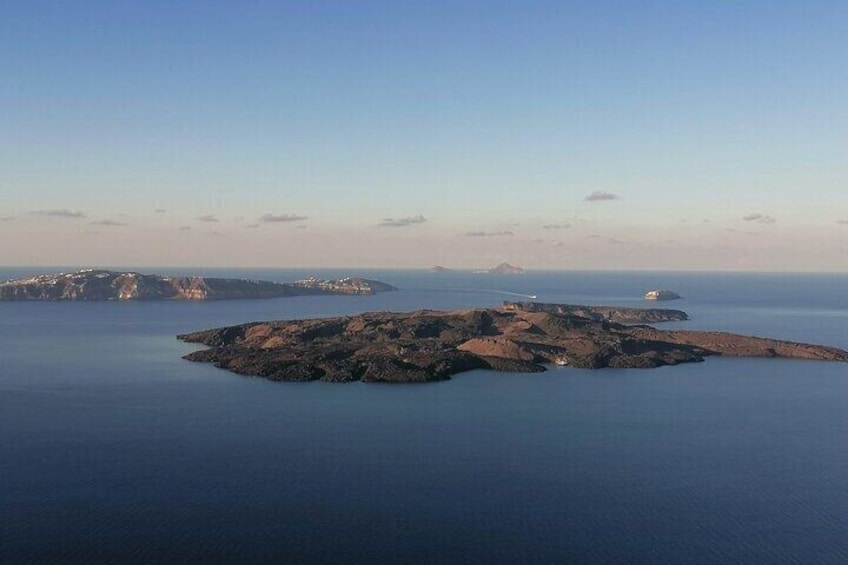 A coastal landscape with a prominent rocky island surrounded by calm waters. 4