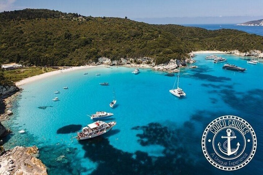 A coastal area with clear turquoise waters, boats, and a logo of a cruise company. 1