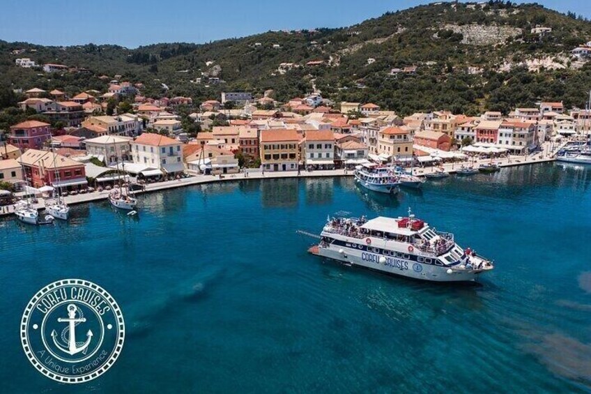 A coastal town with a clear harbor, a boat named 'COFU BUSES,' and a hilly backdrop. 2