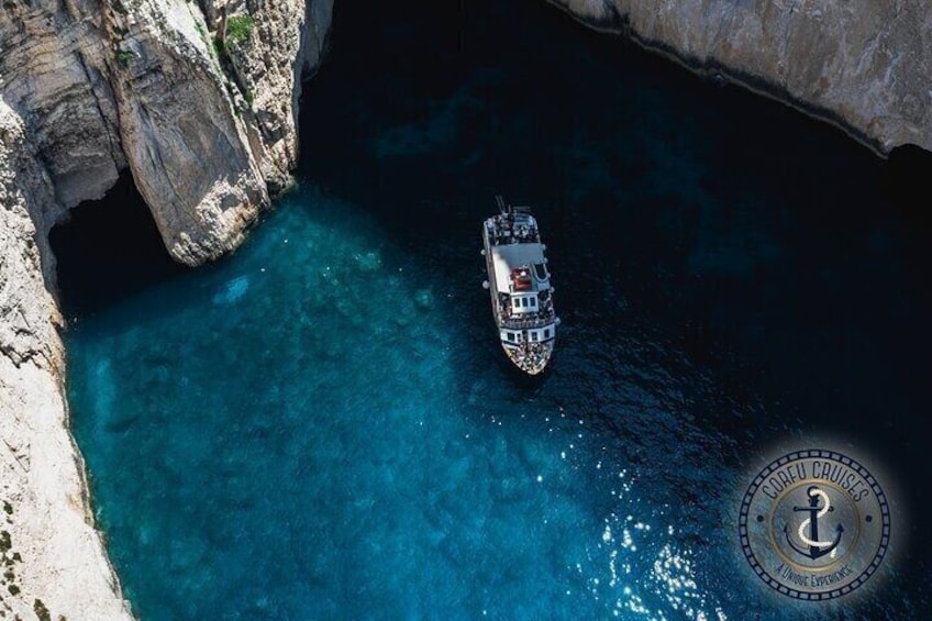 A boat in a clear blue cove surrounded by rocky cliffs. 4