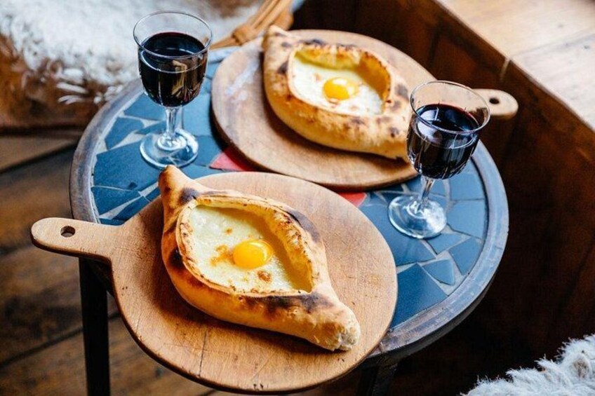 Two bowls of bread with eggs on top, placed on a round table with a blue pattern. 3