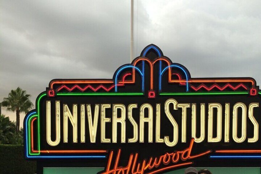 Un letrero de neón de Universal Studios Hollywood con un cielo nublado al fondo. 1