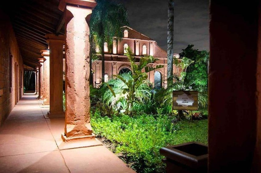 A pathway leading to a historic building with columns and greenery. 1