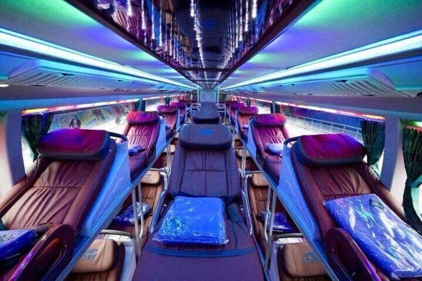 A train interior with reclining seats and overhead compartments. 5