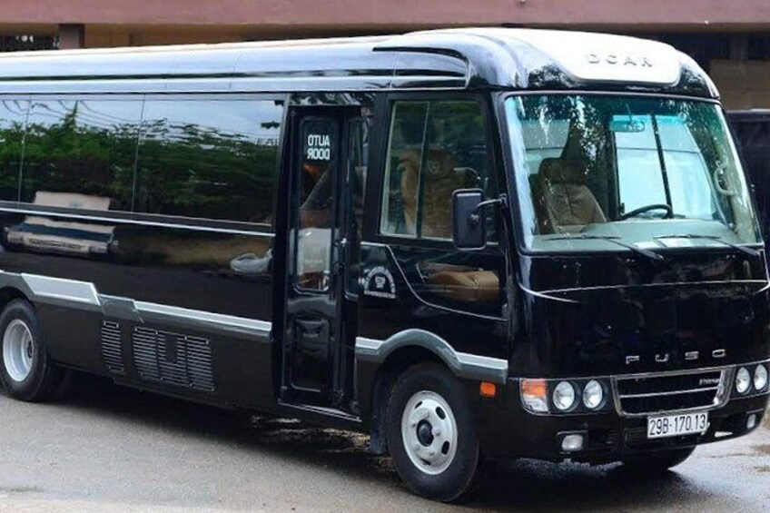 A black bus with the license plate 298-170-13 parked on a street. 1